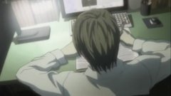 An animated character with light brown hair lies face down on a desk in front of a computer monitor.