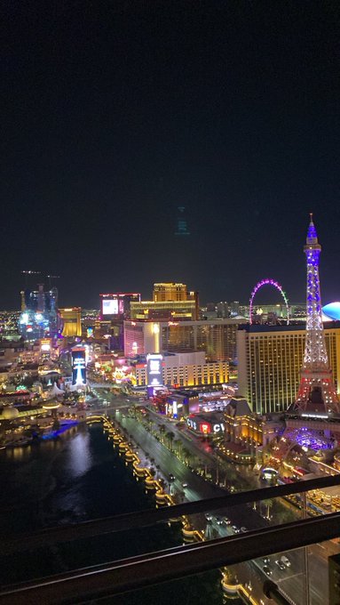 A nighttime view of the Las Vegas Strip showcases the illuminated Eiffel Tower replica, a brightly lit Ferris wheel, and the glowing Bellagio fountains, capturing the iconic skyline that feels like "no place like home" for a Vegas local or lover.