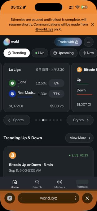 A screenshot of the world.xyz prediction app showing trending markets including a La Liga match (Elche vs Real Madrid on Sept 16) and a "Bitcoin Up or Down - 5 min" live market, with an inactive "Trade with" button highlighted—aligning with the poster's hopeful request for staking rewards in the upcoming second wave of the Worldcoin airdrop.