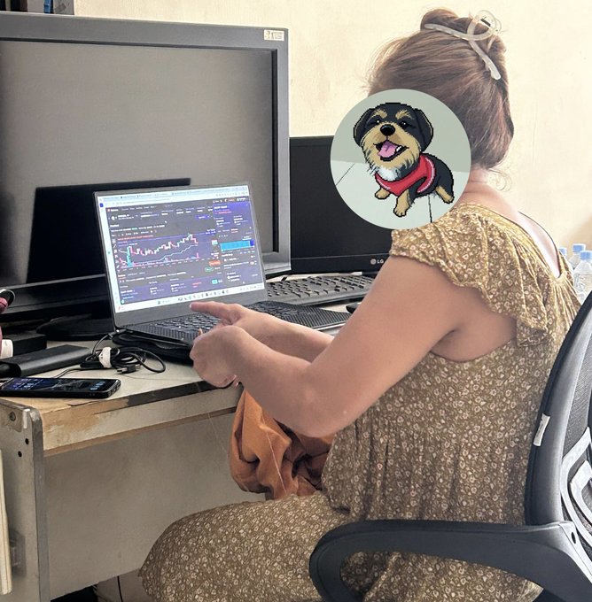 The image features a woman sitting at her desk, wearing a floral dress with a cartoon dog headband on her hair. She has a laptop open in front of her, likely working or browsing the internet. On the desk next to her, there is also a cell phone and a handbag. The post about learning LP from @MeteoraAG seems to be related to the woman's interests, as she enjoys sewing while wearing her unique headband with a cartoon dog on it.