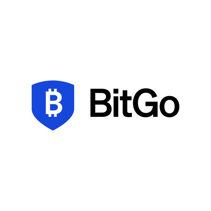 The image displays the BitGo logo, featuring a blue shield with a stylized white "B" (resembling a Bitcoin symbol) alongside the company name "BitGo" in bold black text. This branding corresponds with the announcement of BitGo's acquisition of NYDIG's institutional trading business, highlighting the company's expansion in crypto-related financial services.
