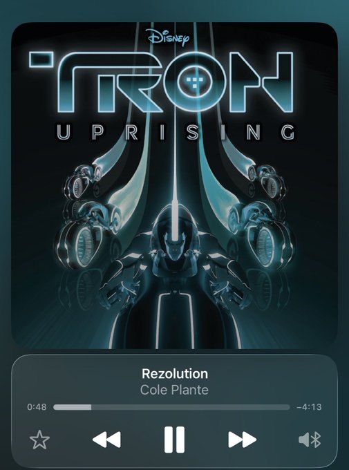 A music player interface displays the album cover for Disney's "TRON: Uprising" soundtrack by Cole Plante, featuring the iconic glowing blue armor and light cycle imagery, with the track "Rezolution" paused at 0:48 of a 4:13 runtime. The caption aligns with the post, as the album art showcases the highly acclaimed score from the animated series that fans consider among the best in the Tron franchise.