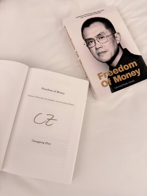 Two copies of the book "Freedom of Money: A Memoir of Protecting Users, Resilience, and the Founding of Binance" by Changpeng Zhao.