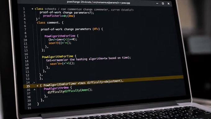 A laptop screen displays C++ code for a proof-of-work change commenter with classes cshorts and comment, including PowAlgorithmForTime functions adjusting difficulty based on time.