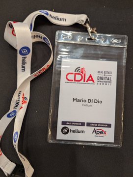A Helium-branded conference badge identifies "Mario Di Dio" as a speaker at the CDIA (Commercial Digital Infrastructure Alliance) Real Estate & Digital Infrastructure Summit, with logos for Helium, Apex, and Summit visible at the bottom—reflecting his participation alongside industry leaders discussing infrastructure improvements for mobile experience and Wi-Fi monetization.