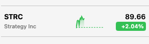A blurry stock widget showing MSTR (Strategy Inc) at $89.66 with a +2.69% gain, indicated by a green upward chart.