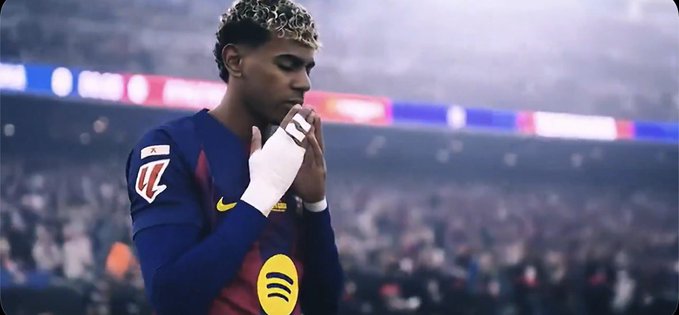 A soccer player wearing a Barcelona jersey with 'W' and 'Spotify' logos is shown with his hands clasped in a prayer-like gesture on the field.