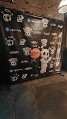 A black backdrop covered with various cryptocurrency and Web3 company logos, including Opera, Matrixport, and 0G, set up in an industrial space.