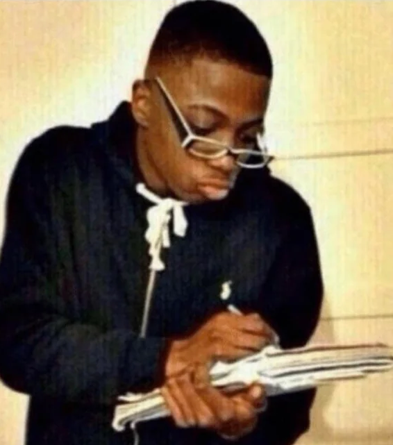 A young man wearing glasses and a dark hoodie carefully jots down notes on a notepad. The image humorously illustrates the post's joke about crypto influencers who obsessively log every ticker and memecoin recommendation, frantically writing down each "100x" pick.