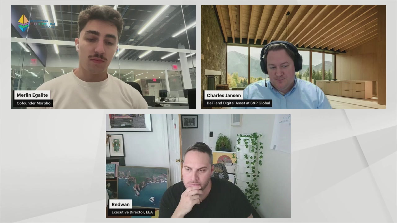 The image shows three people sitting at a table, with each person facing different directions as they appear on separate screens within the same frame. The background of the image features a white wall with a window that allows natural light into the room. The text "Special Edition" is visible in the image, and it appears to be related to an event or gathering taking place at a company named "Enterprise".