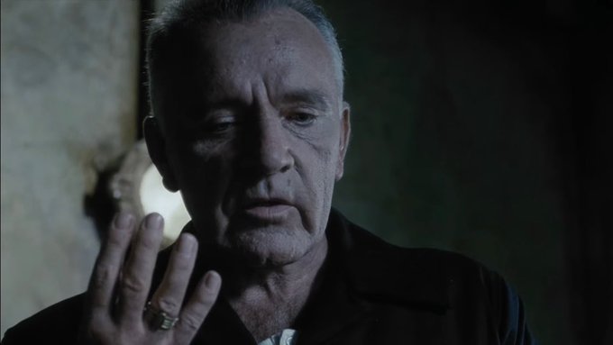 The image shows a man wearing a black jacket standing against a dark background. He has his hand raised to his face, possibly pointing or gesturing towards something. The caption above the image reads "In the Orwellian world of bitcoin these days, money is not money, capital is not capital, credit is not credit, actual capital is replaced with Digital Alchemy!". This post seems to be discussing Bitcoin and its impact on traditional financial systems.

The man's position in front of a wall adds an element of depth to the image, making him appear larger than life. The dark background further emphasizes his presence and draws attention to him as the main subject of the photo.