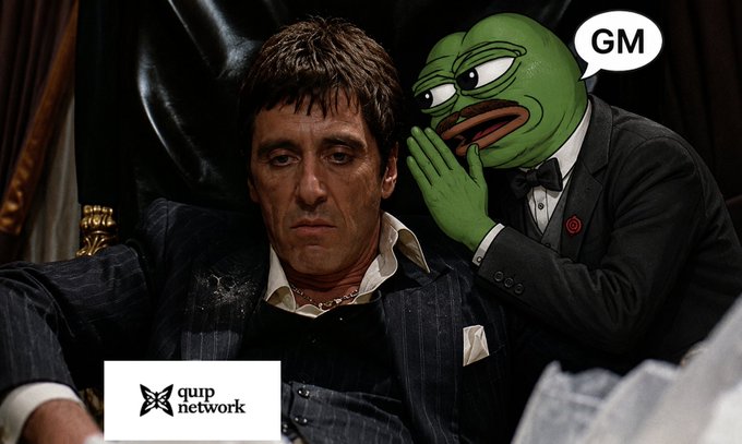 A scene from the movie Scarface featuring Tony Montana in a suit, with a Pepe the Frog photoshopped next to him whispering, accompanied by a speech bubble saying "GM" and a "quip network" logo in the bottom corner.