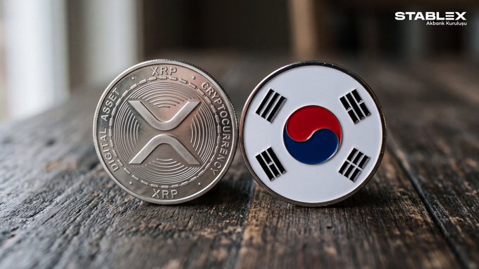 Two cryptocurrency tokens on a wooden surface - one silver XRP coin marked 'DIGITAL ASSET CRYPTOCURRENCY XRP' and one white coin featuring the South Korean flag, with 'STABLEX Akbank Kuruluşu' branding in the upper right corner.
