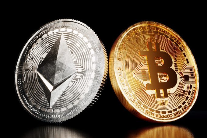 A close-up photograph of two physical cryptocurrency coins against a black background: a silver Ethereum (ETH) coin on the left and a gold Bitcoin (BTC) coin on the right.