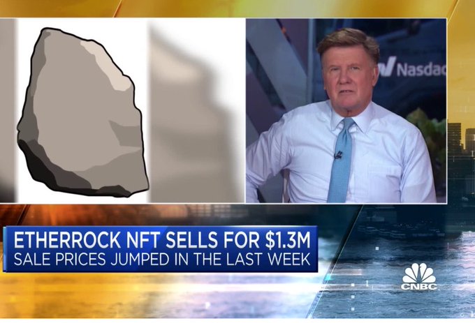 The image features a man sitting at a desk, wearing a white shirt and tie, with his head in his hands. The scene takes place over a cityscape background that shows buildings of various sizes and colors. The main focus of the image is a large rock depicted as a gray stone, placed to the right side. Above this rock, there's a post on a TV screen discussing a cryptocurrency called Ethercraft NFT selling for $1.3M in just one week.