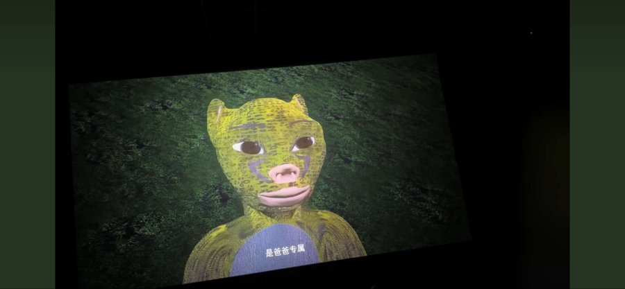 The image shows a projected display of a yellow-green cartoon leopard character with pink lips against a dark textured background, with Chinese subtitles reading "是爸爸专属" (meaning "is exclusive to dad").

The cartoon leopard appears unrelated to the post's message about a bull, suggesting the poster may have shared this image by mistake.