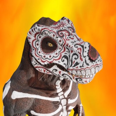 A T-Rex figure decorated with Day of the Dead sugar skull face paint and skeleton body details against a fiery orange background.
