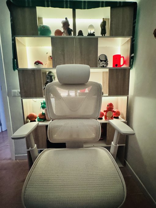 A new beige ergonomic mesh chair is shown in front of a display shelf filled with various figurines, including a Stormtrooper helmet and Pokémon plushies like Charmander and Bulbasaur. The post showcases the 0.1 ETH chair purchase in what looks like a personal hobby room setup.