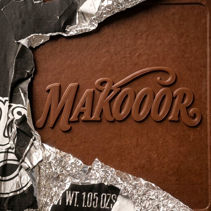A partially torn chocolate bar wrapper reveals brown chocolate with the embossed word "MAKOOOR" and "WT. 1.05 OZS" visible on the foil.