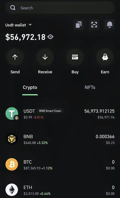The image shows a phone screen displaying various cryptocurrency transactions, including Bitcoin, Etherium, and Dogecoin. The text on the screen reads "Still here, still grinding. I love crypto!", which suggests that the user might be engaged in cryptocurrency trading or investing activities.