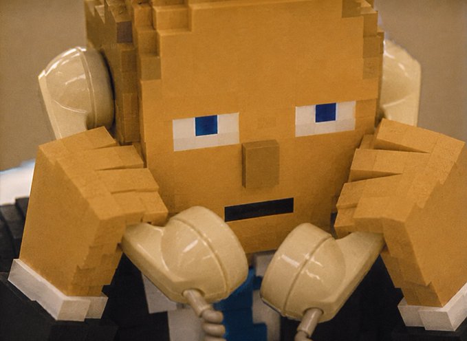 A pixelated block figure with blue pixel eyes and beige gloves appears to be in a fighting or boxing stance, its clenched fists raised up near its face. The caption "Clocked in double time" cleverly plays on the boxing theme, suggesting the character has been punched or is throwing rapid punches.