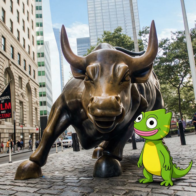 A bronze Charging Bull statue stands on a cobblestone street in a city, with a cartoon green lizard digitally placed next to its front leg.