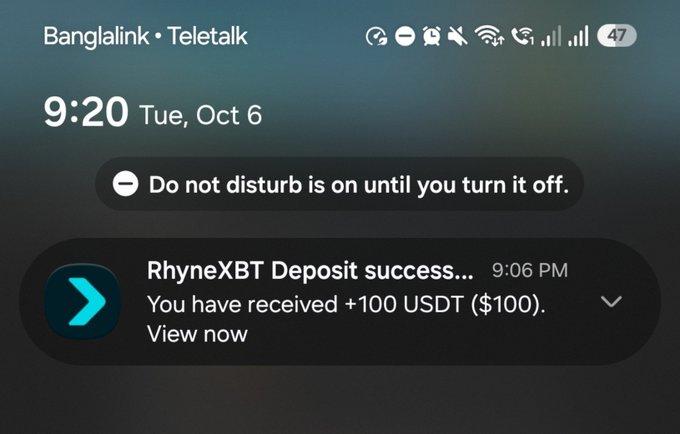 Smartphone lock screen screenshot showing a notification from RhyneXBT that reads 'Deposit success... You have received +100 USDT ($100)' above a 'Do not disturb' banner.
