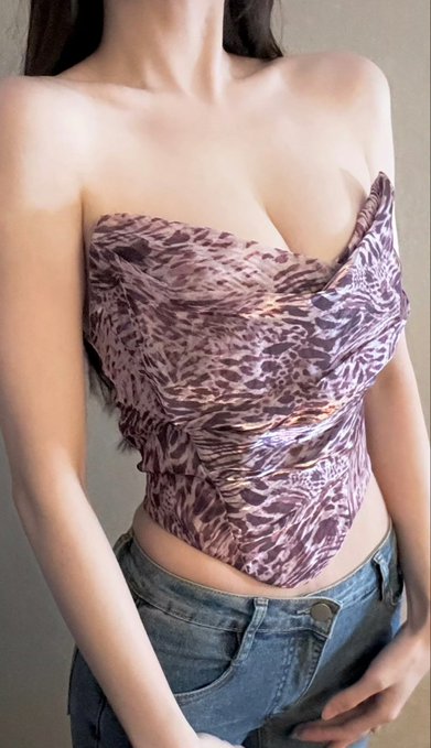 A woman with a large bust poses in a strapless mauve animal-print top and low-rise jeans, visually supporting the post's playful flex about having "big brains... wait, big-boobs" despite her self-admitted trading losses. No text, numbers, or branding are visible in the image.