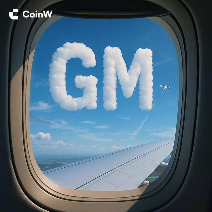 A view through an airplane window shows blue sky, clouds, and the airplane wing, with the letters 'GM' shaped out of white clouds and a 'CoinW' logo in the top left corner.