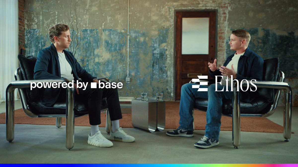 Two men sit in black leather chairs facing each other in a discussion setting, with logos for 'powered by base' and 'Ethos' overlaid on the image.