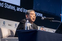 SBI Chairman Kitano delivers a keynote speech at WebX2026, with partial text "United States, and Ira" and "everyone" visible on the screen behind him, as he shares his bold prediction that RWA (real-world asset tokenization) could grow to 100,000 times its current scale.