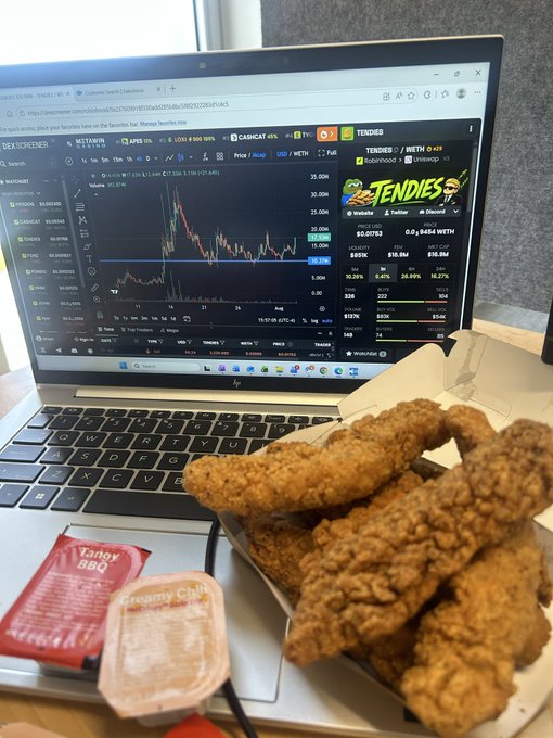 A laptop displays a TradingView chart for the ticker 'TENDIES' showing a meme coin page with price data, next to a box of fried chicken tenders and dipping sauces labeled 'Tangy BBQ' and 'Creamy Cajun'.