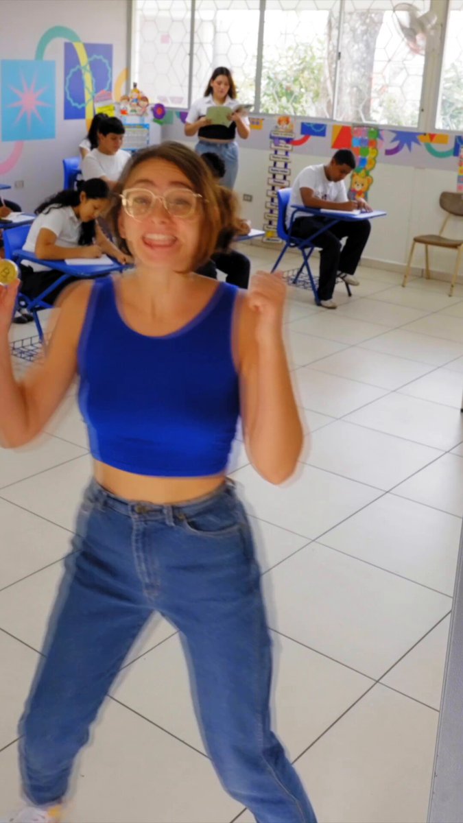 The image shows a woman wearing blue jeans and glasses standing in front of a white tiled wall with a window, smiling at the camera while holding her hands up in the air. The background reveals that there are other people present as well, suggesting that they might be students or teachers participating in an educational event. The post about Bitcoin being taught in schools is related to this image because it implies that the woman could potentially be involved in teaching Bitcoins or cryptocurrency to the students at the school.

The presence of a window and chairs indicates that the room may serve as a classroom, where students can learn about Bitcoin and other digital currencies. The fact that El Salvador has decided to teach Bitcoin in every school shows an interest in embracing new technologies and potentially exploring opportunities for financial inclusion or economic growth through digital assets like Bitcoins.