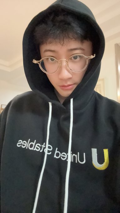 A selfie of a young man with glasses wearing a black United States Geological Survey hoodie, looking directly at the camera.