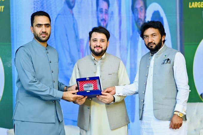The image features three men standing next to each other with a blue box between them. One of the men is holding up an award for Best Privacy Champion. The man receiving the award has a beard, while his two companions are wearing white shirts. They appear to be at a formal event or ceremony where they have been recognized for their contributions in the field of privacy and blockchain technology.