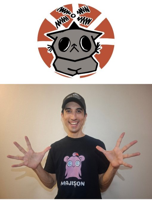 A smiling man wearing a black cap and a 'MAJISON' t-shirt poses with his hands up under a cartoon logo featuring a gray cat-like character with springs on its head.