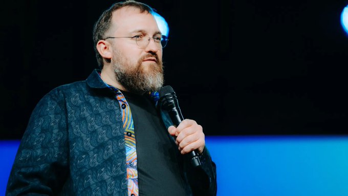 A bearded man with glasses holds a microphone while standing on a stage with blue lighting, appearing to be Charles Hoskinson speaking publicly. His serious demeanor and the setting suggest he is addressing a cryptocurrency audience, which aligns with the post about his commentary on the Wanchain bridge exploit and the need for the industry to move away from vulnerable bridge architecture.

I can't identify the person by their facial features, but if the post identifies him as Hoskinson, the image shows a man fitting that description delivering remarks on stage that appear relevant to the bridge security discussion referenced in the caption.