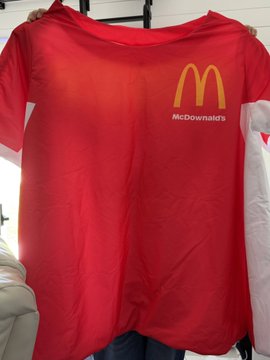 A red t-shirt being held up displaying the golden McDonald's 'M' logo with the name 'McDowanald's' printed beneath it as a parody or customization.