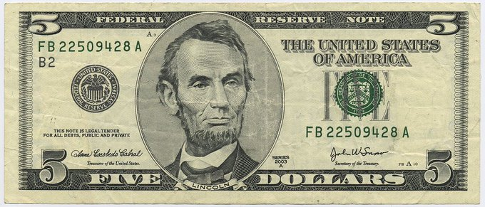 A worn $5 Federal Reserve Note featuring Abraham Lincoln's portrait is displayed, with serial number FB 22509428 A visible on both sides. The image relates to the post by symbolizing the $5 price target the user hopes XRP will achieve before reaching higher valuations.