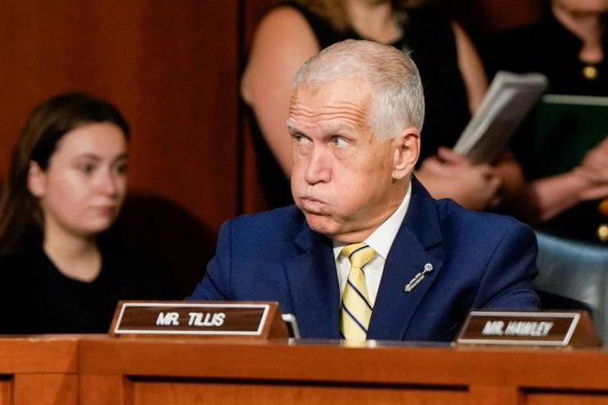 Senator Thom Tillis (R-NC), seated at a Senate committee hearing with his name placard visible, appears to be referencing the bipartisan stance on a digital assets bill mentioned in the accompanying post. The image shows him in a formal blue suit with a yellow striped tie, looking serious, with a "Mr. Hawley" nameplate visible to his right, suggesting the context of a legislative debate.