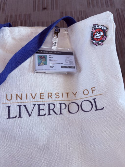 A University of Liverpool tote bag holds an ID card and a Bored Ape Yacht Club (BAYC) pin, with the post referencing the traveler's recent connections with BAYC community members in Shanghai en route home.