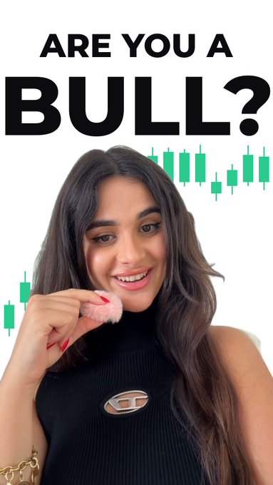 A young woman smiles while holding a small fluffy pink object near her face, with the bold text 'ARE YOU A BULL?' and green stock chart candlesticks displayed behind her.
