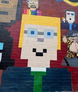 A vibrant pixel-art mural features a blocky character with yellow hair, blue glasses, and a pixelated smile, with "RAY" visible in the background. The graffiti-style, tech-forward artwork complements StonkBrokers' message of long-term vision and multi-platform ecosystem growth beyond Web3.