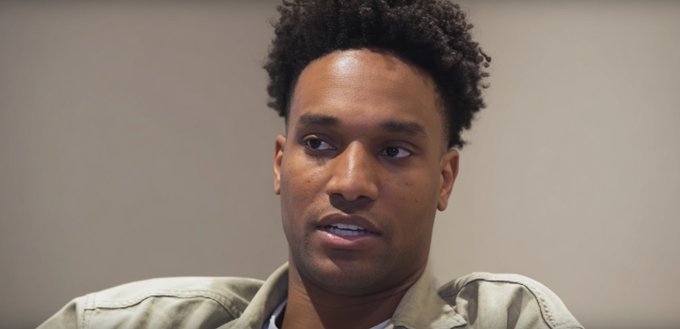 A young man with curly hair, wearing a light olive jacket, appears to be speaking during an interview or press conference, with a neutral expression. The image likely relates to the post as a reference to ANSEM, a crypto personality known for his commentary on trading risks and common mistakes.