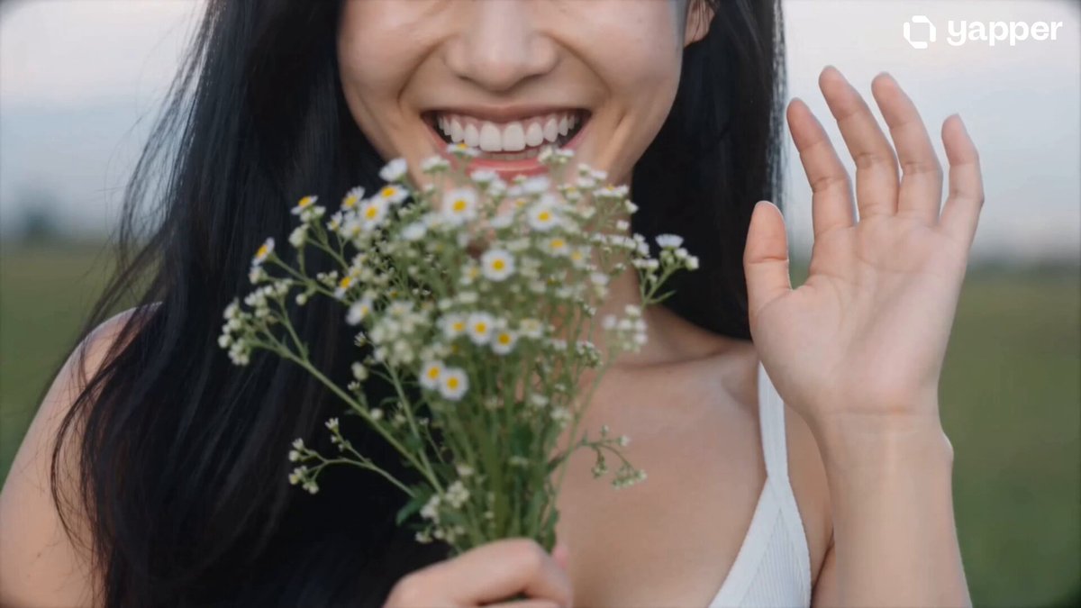 The image features a woman holding aloft a bunch of flowers with green centers, looking happy as she poses for a photo. In the background, there are words that describe her actions like "gm @grok" which could be a nickname or an account name, and "staking boosts rewards by up to 20%". Additionally, there is text indicating that every click would contribute towards her participation in creating an AI network that helps earn ownership through real tasks. The overall scene conveys a connection between the act of taking photos and potentially earning online staking in return.