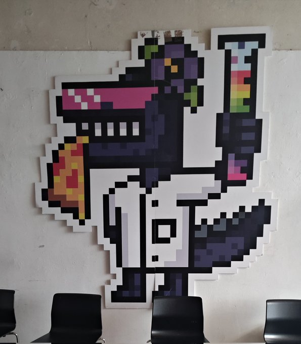 The image features a large, colorful cartoon dinosaur statue with a pizza slice in its mouth. The dinosaur appears to be wearing a lab coat and holding a test tube. There are several chairs arranged around the scene, suggesting that this might be an event or gathering related to the #RoninDyno project during Berlin Blockchain week. The post also mentions Spicy Lava Shot as a creative piece of art at the event.