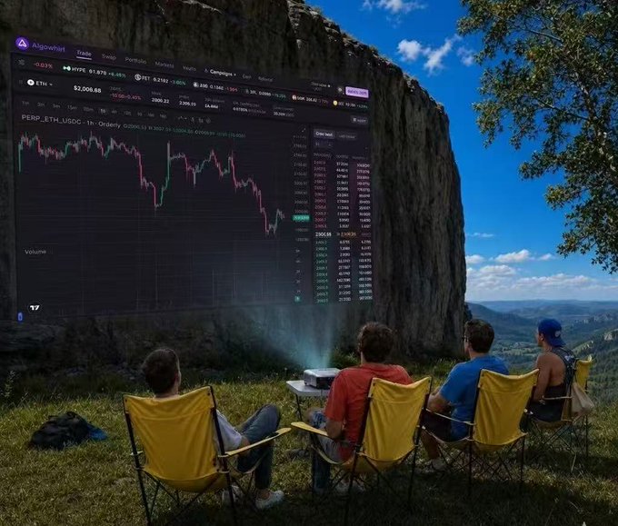 The image captures an outdoor camping scene where a group of people are sitting around a projector screen, which displays cryptocurrency information such as Bitcoin graphs. The participants seem to be engaged and interested in this content. A few chairs can be seen around the screen with at least four people seated on them. Some individuals appear more focused on the screen than others.