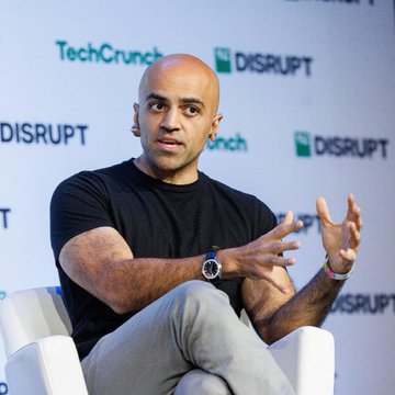 Haseeb Qureshi, managing partner at Dragonfly, speaks on stage at TechCrunch Disrupt against a backdrop featuring the event's "TechCrunch Disrupt" branding. The image illustrates the accompanying article, where he comments that the so-called DeFi "hackpocalypse" was overstated, with dollar losses in 2026 tracking below 2025 despite more frequent attacks.
