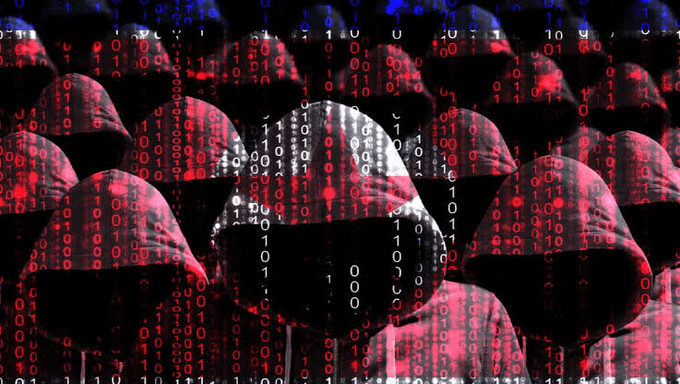 A central hooded figure, illuminated in white and surrounded by a crowd of red-hooded figures, is overlaid with cascading streams of binary code (1s and 0s), visually representing a coordinated cyber threat. The imagery directly relates to the post by symbolizing the anonymous, collective nature of the Lazarus Group as they are suspected of carrying out digital heists like the recent Bitget hack and the $1.5 billion Bybit breach.