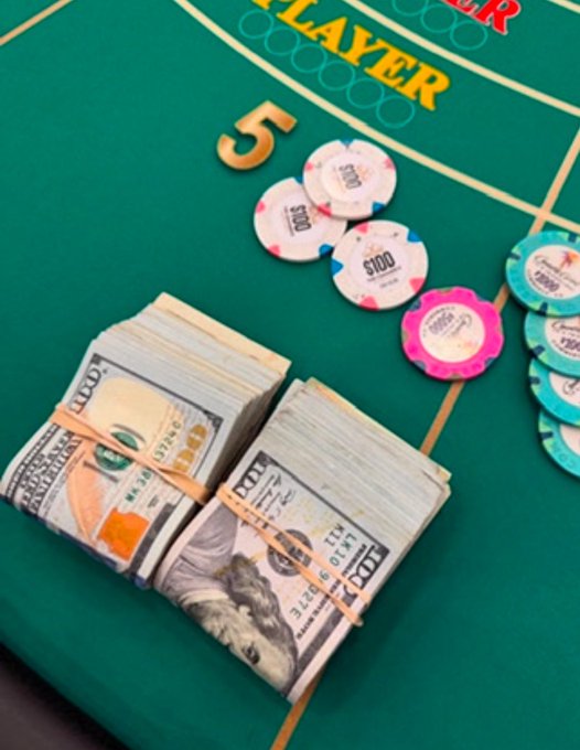 A close-up of a casino-style gaming table featuring stacks of $100 bills secured with rubber bands alongside colorful poker chips and a "PLAYER" label, with the caption celebrating Friday casino winnings.